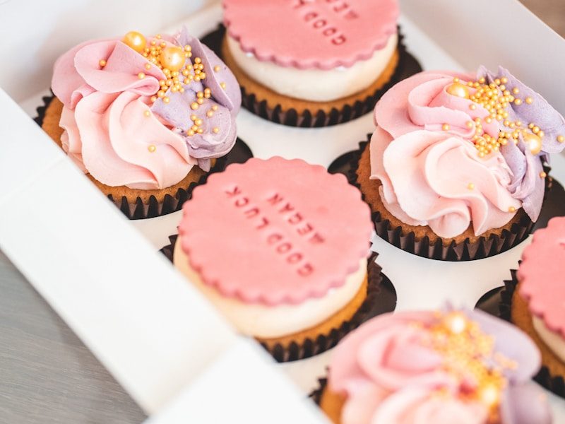 a box of cupcakes with pink frosting